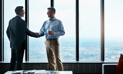 two men shaking hands in an office